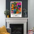 Covent Garden Flower Market Wall Art black frame on a fire place featuring illustrated tropical flowers and foliage in a vibrant flower market poster, with London location typography.