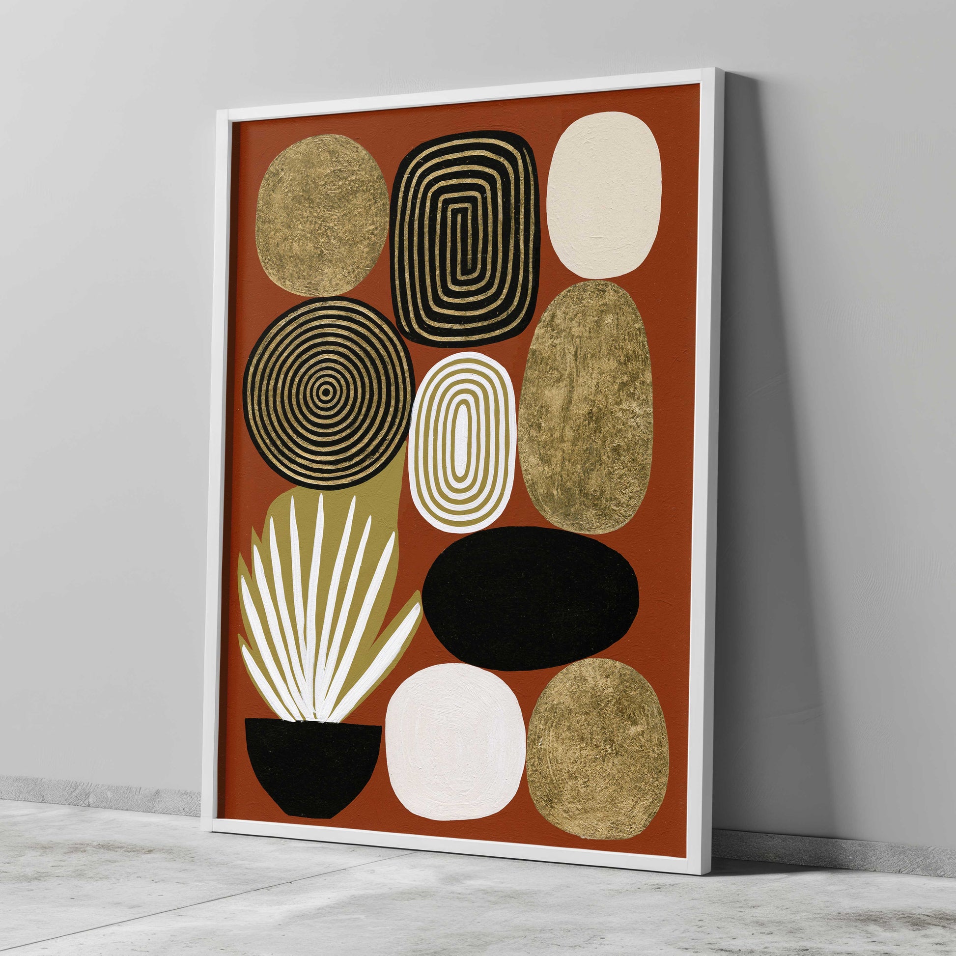 Mid century modern boho abstract art print featuring a collection of stacked geometric pebble shapes on a rust terracotta background. Designs include gold foil textured stones, black concentric circles, concentric white and gold rings, and a potted white spike plant in a black bowl