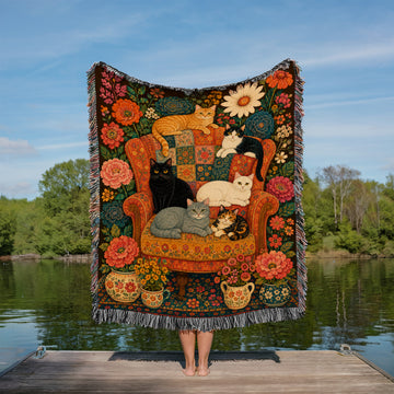 Floral cat woven throw blanket with six cats on a patterned armchair surrounded by flowers
