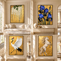 Four framed wall art pieces displayed in a bright, elegant living room setting. The artworks feature a gold background: white wisteria flowers, deep blue irises, a white crane, and a white horse rearing up.