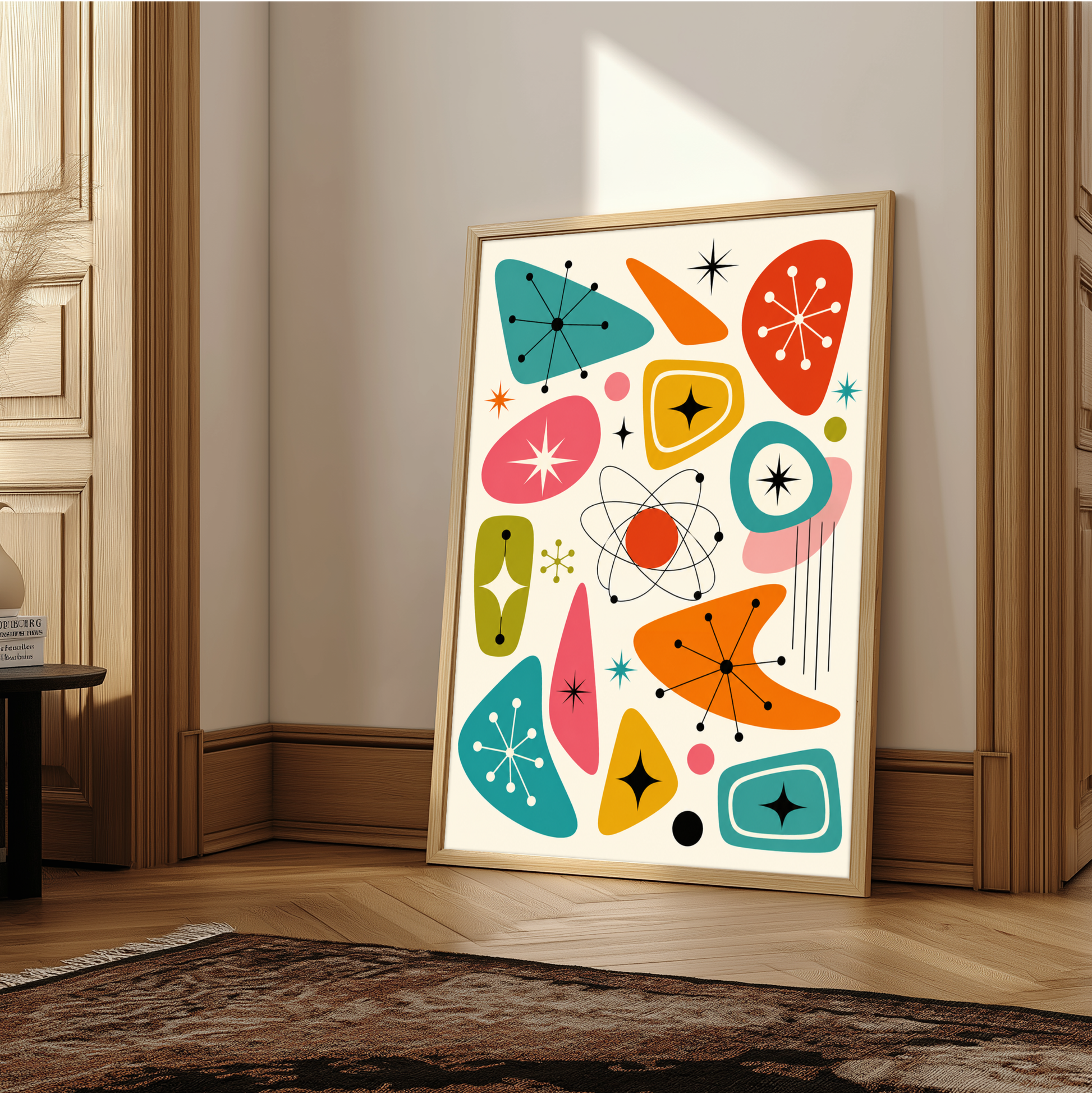 Vintage 1950s atomic age graphic art print featuring an abstract pattern of retro boomerang shapes, kidney beans, starbursts, sparkles, and a central atom symbol with orbits. The design uses teal, orange, pink, yellow, and olive green on a cream background