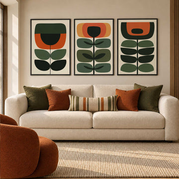 Mid century botanical wall art set of 3 with geometric green, burnt orange and ochre flowers and leaves on cream backgrounds.