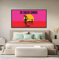 The Endless Summer official licensed panoramic framed canvas art print John Van Hamersveld neon pink orange sunset gallery canvas  Framed artwork titled 'The Endless Summer' above a bed in a bedroom.