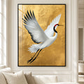 Flying crane wall art print in a thin black frame, displayed in a cream living room with gold and neutral interiors
