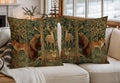 Two decorative throw pillows with a detailed woodland art print featuring deer, bears, and foxes, styled on a white sofa in a cozy, sunlit living room.